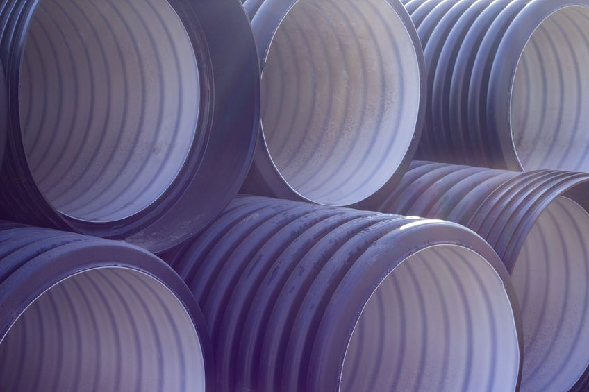 pipe texture background. New black and white plastic pipes for sewerage system. sewage and water supply Close up of a bobcat or skid loader